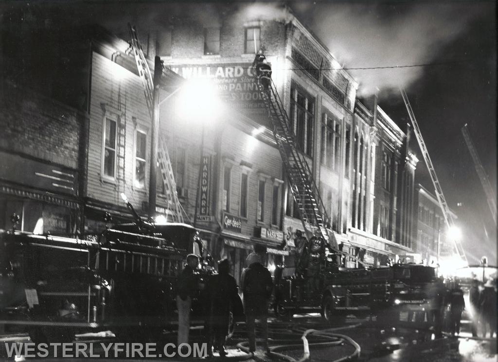 Box 1122-January 8, 1963- A view of the front of the building as Westerly, Pawcatuck and Watch Hill firefighters go to work. This photos shows 3 aerial ladders operating for the first time downtown.