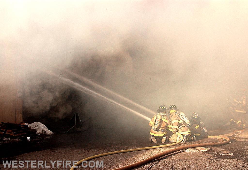 Box 1313-February 4, 2004-Westerly firefighters partially obscured by smoke operate 2 lines into the warehouse.