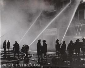 Box 3111-March 14, 1975-Firefighters pour water into the front of the Potter-Langworthy Building.
