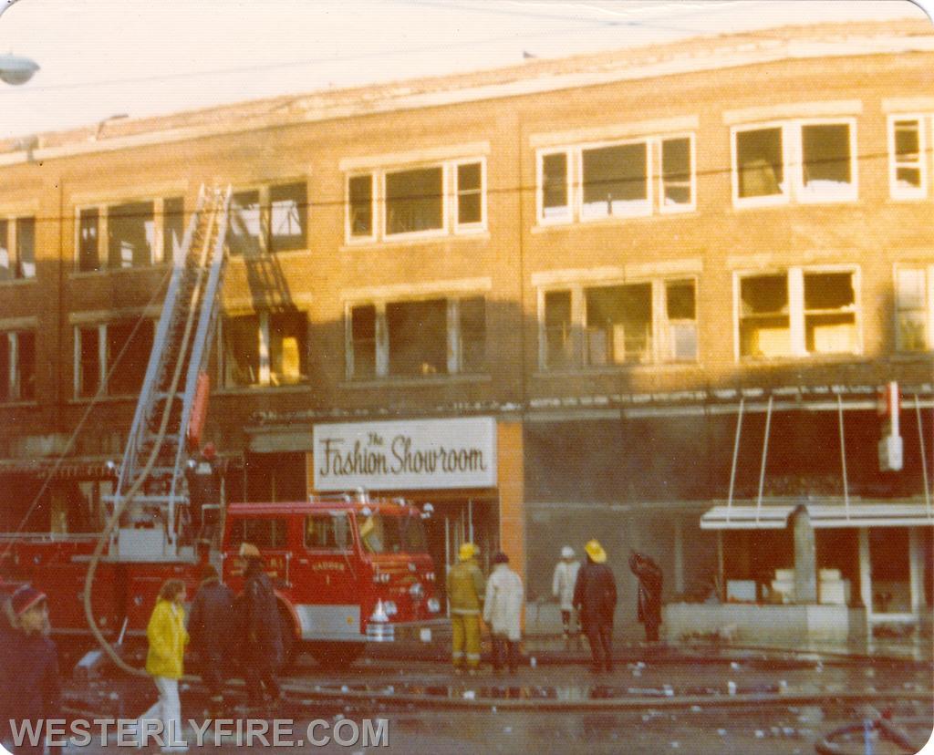 Box 3111-March 14, 1975-Westerly Ladder 1 flows its ladder pipe into the third floor. Debri litters High St.