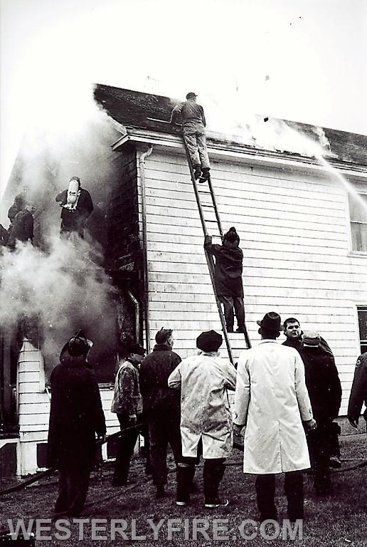 Box 1253-4/6/1964-Firemne begin to move inside as well as work the exterior at 144 Granite St. Note the member on the porch roof with an air pack.