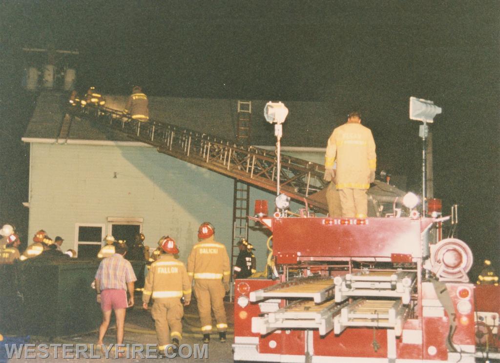 Box 1123-7-17-1994-117 Main St.-Members of Ladder 1 ascend the aerial to ventilate the roof on the D-side.