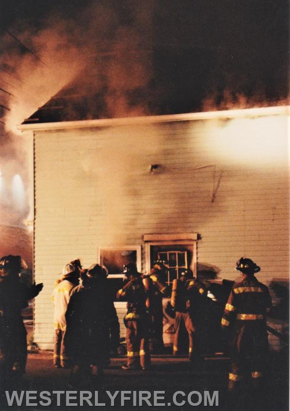 Box 1123-7-17-1994-117 Main St.-Firefighters force entry to attack the fire from the front.