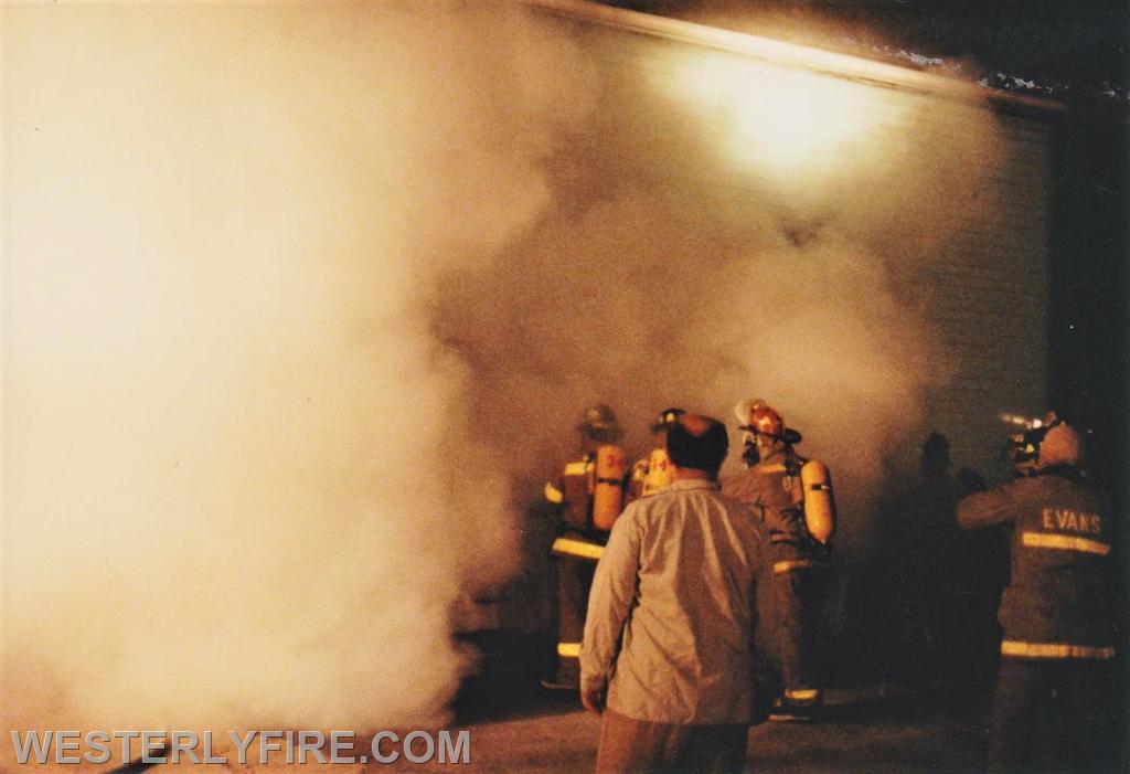 Box 1123-7-17-1994-117 Main St.-Heavy Smoke envelopes firefighters as the make entry into the building from the D-side.