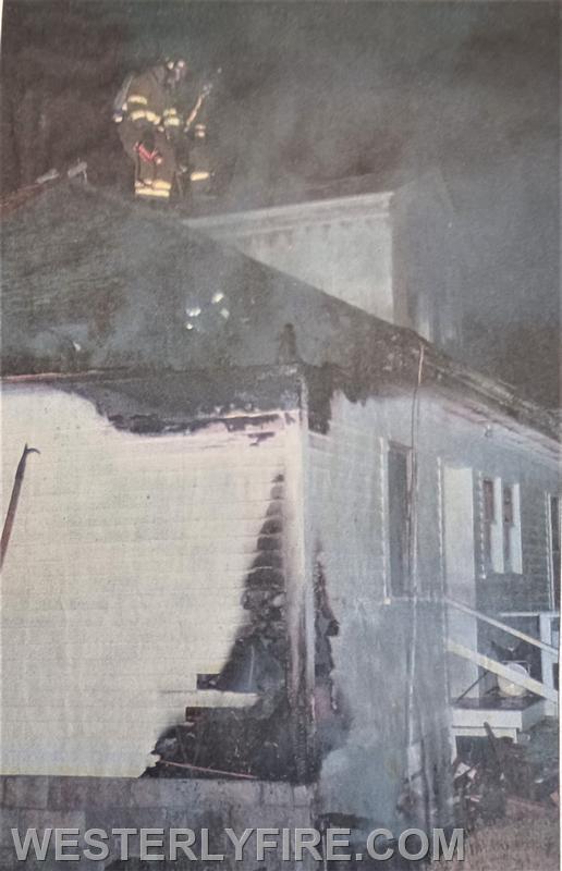 Box 3213-January 2,1999- Firefighters overhaul the scene at 8 Joshua St. Note the damage to the corner of the house and attic showing the path of the fire.