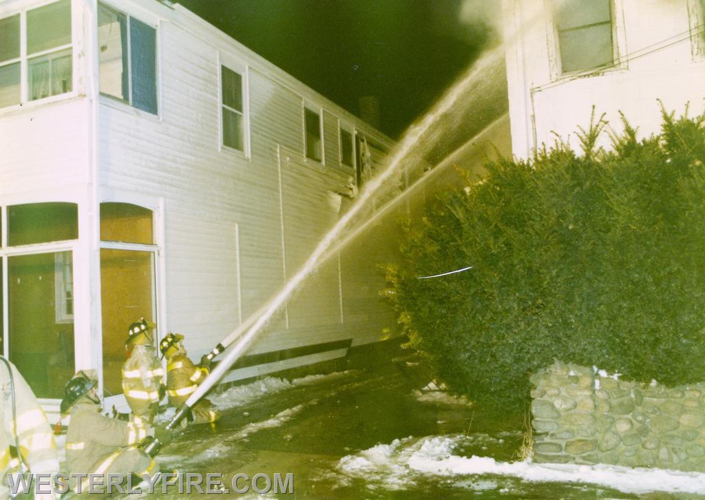 Box 4113-February 18, 1996-Westerly firefighters work to keep the fire from extending to the next house. Note melted siding behind the hose streams.